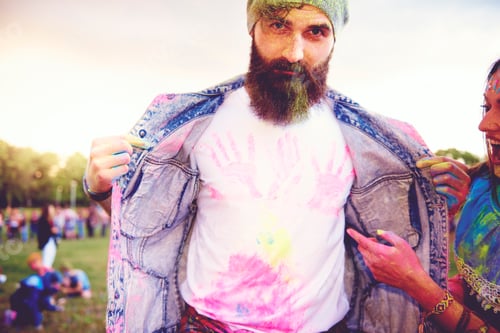 Preview: Portrait of young male hipster with chalk handprints on tshirt at festival