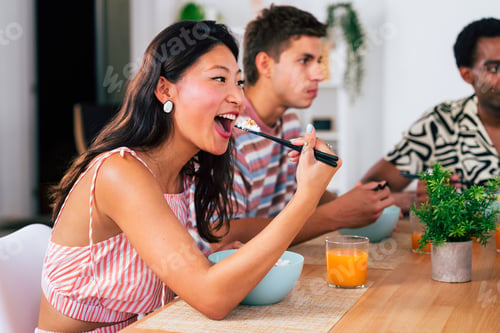 Preview: Multiethnic group of young friends meeting at home and eating poke bowls