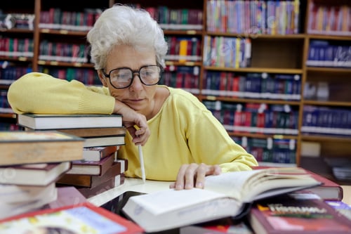 Preview: Elderly Woman in Library Reading a Book
