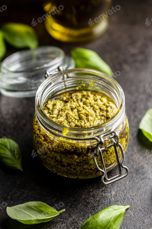 Preview: Green basil pesto dip sauce and basil leaves.