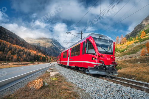 Preview: Red passenger train is moving on railway in swiss alps at sunset