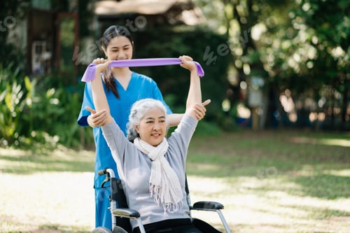 Preview: Asian young caregiver nurse support senior older female walking outdoors.