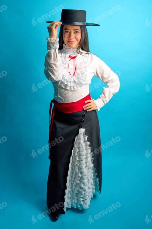Preview: Studio portrait of a young latina woman proudly wearing a traditional chilean huasa dress