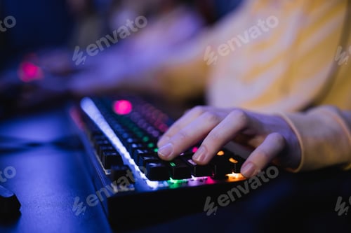 Preview: Cropped view of gamer using keyboard with lighting in cyber club