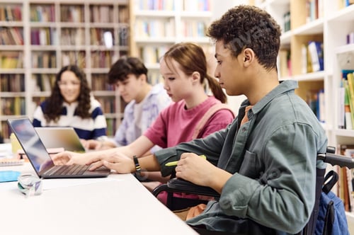 Preview: Diverse Group of Students using Computer in Library in Row