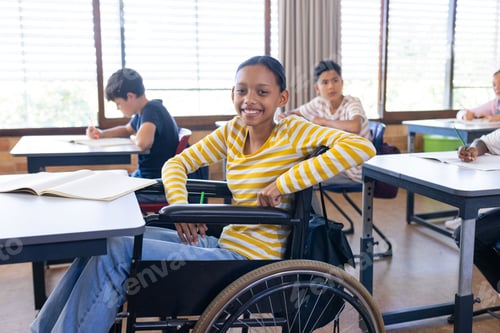 Preview: In school, girl in wheelchair smiling and studying with classmates in classroom