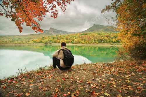 Preview: Man sitting alone on the pond.