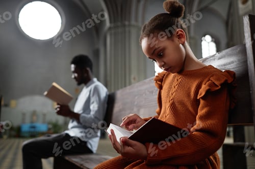Preview: Little girl reading Bible in church