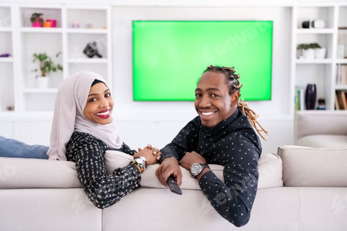 Preview: African Couple Sitting On Sofa Watching TV Together