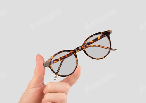 Preview: Stylish women's glasses of leopard color in a man's hand. Male hand holding female eyeglasses