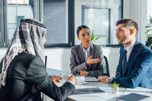 Preview: multicultural business partners talking on meeting with translator in office