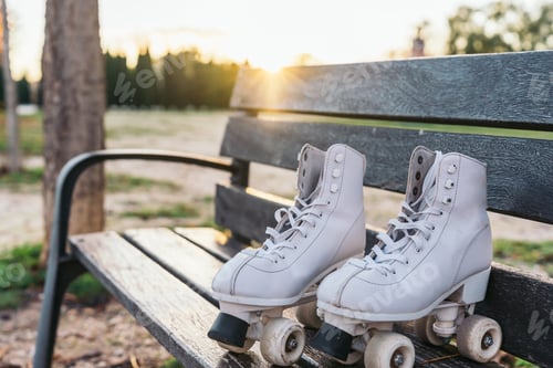 Preview: Abandoned Quad Roller Skates on a Wooden Bench.