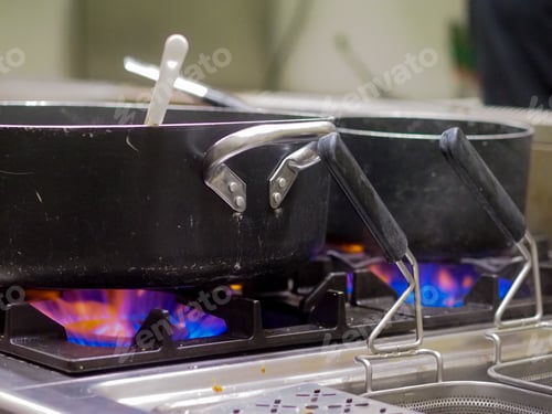 Preview: chelf cooking at restaurant kitchen firing gas stoves and black pro pots