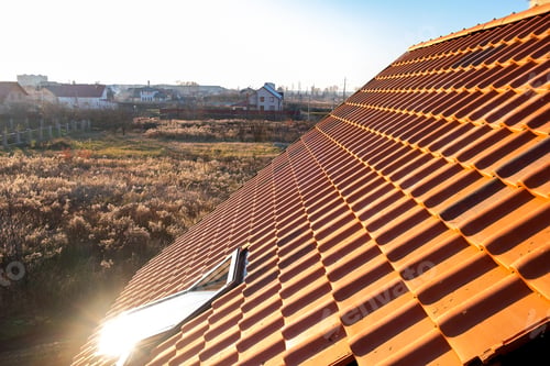 Preview: Overlapping rows of yellow ceramic roofing tiles covering residential building roof