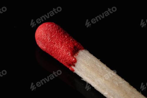 Preview: Macro shot of a wooden match, with red phosphorus on the top, on a black background