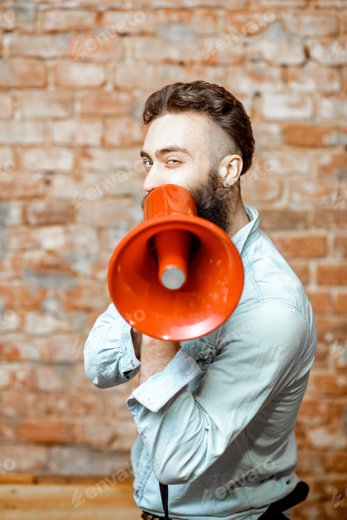 Preview: Man with loudspeaker on the brick background