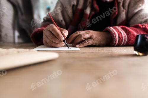 Preview: Old man with dirty hands writing a letter using a nib pen and in