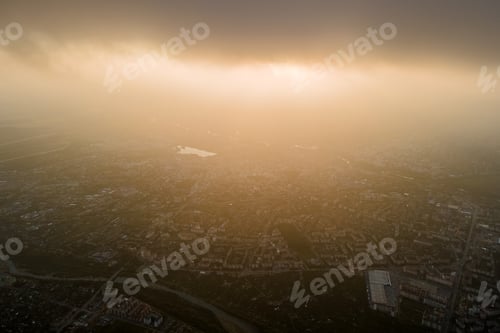 Preview: Aerial view from high altitude of distant city covered with puffy cumulus clouds flying by before