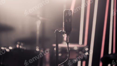Preview: Microphone in recording Studio or concert hall close-up, with drum set on background out of focus.