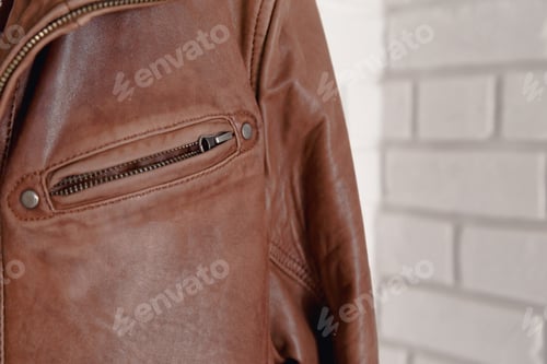 Preview: Brown leather jacket hanged on white wall hanger