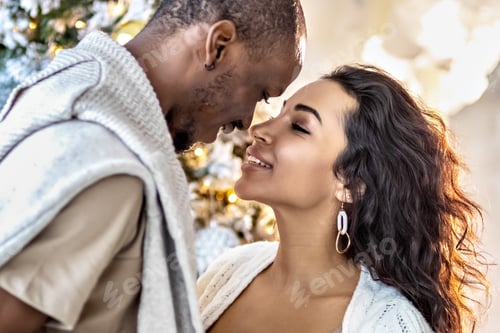 Preview: A happy couple in love mulattoes exchange gifts at the Christmas tree.Celebrating Christmas