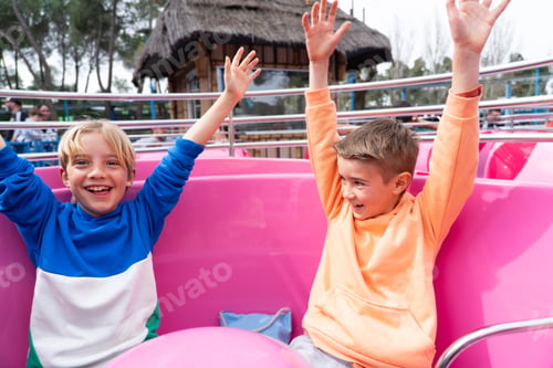 Preview: Two 8 year old Caucasian children having fun on the cup ride at an amusement park.