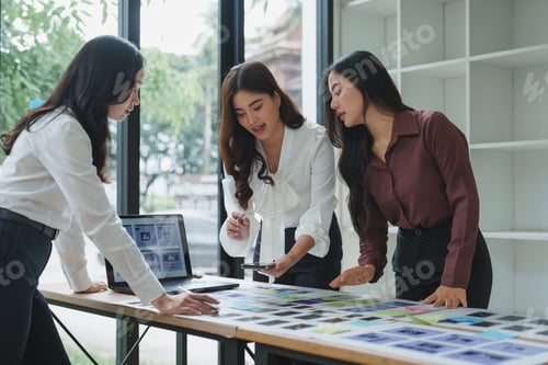 Preview: Businesswomen working together using sticky notes and devices in office