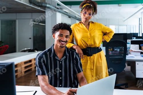 Preview: Young smiling colleagues working together in modern startup office