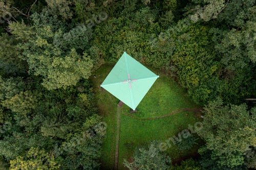 Preview: Overhead perspective of a observation tower cabin nestled in lush woodland during daylight hours.