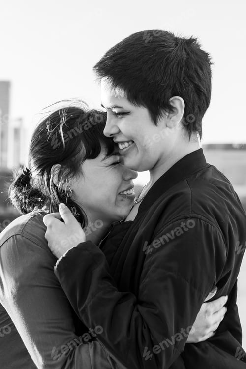 Preview: Black and white portrait of a couple of women embracing and laughing together