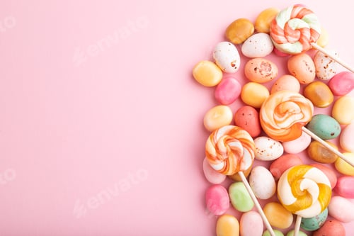 Preview: Various caramel candies on pink background. copy space, top view