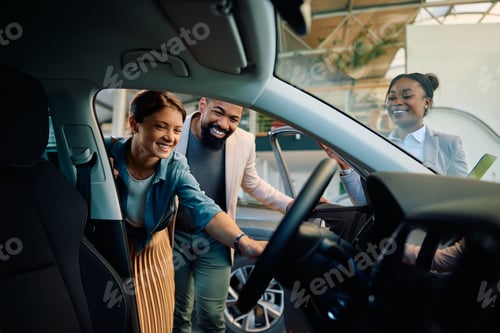 Visualização: Casal multirracial feliz procurando um carro novo no showroom.