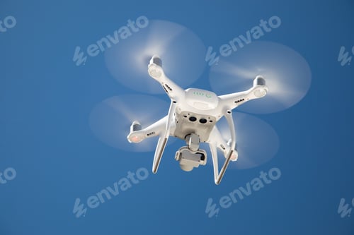 Preview: Drone Quadcopter From Below Against A Blue Sky