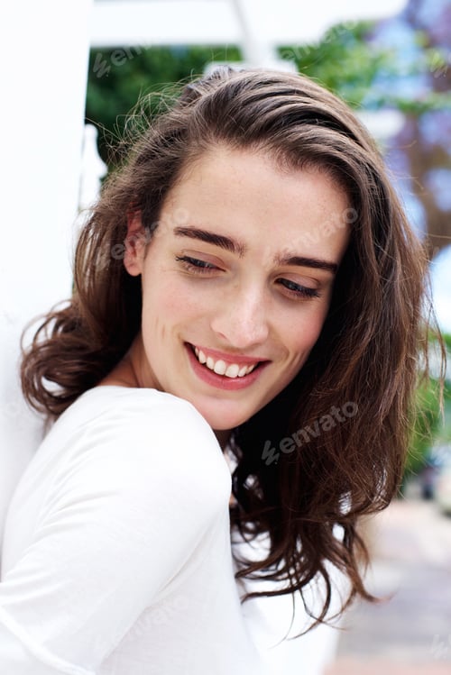 Preview: Beautiful young woman standing outdoors smiling
