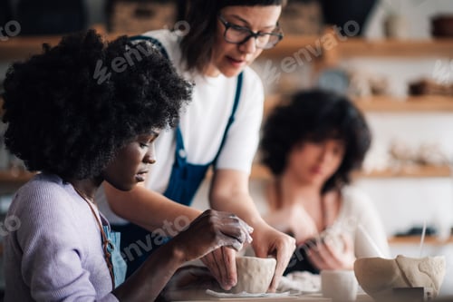 Preview: Interracial pottery class students learning making pottery and earthenware