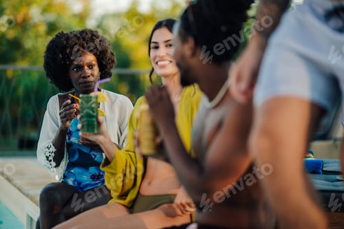 Preview: Friends enjoying cocktails by the pool during summer vacation