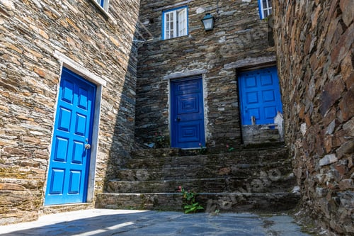 Preview: Stone building with blue doors under sunlight in Piodao village in Portugal