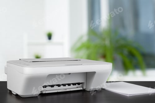 Preview: Compact laser printer on black desk against blurred background