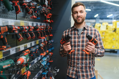 Preview: handsome young man shopping for tools at hardware store
