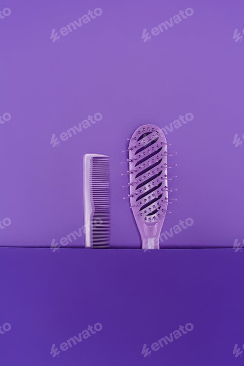 Preview: close up view of purple hairbrush and comb isolated on purple