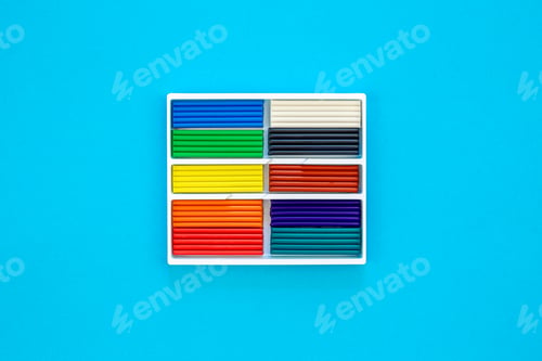 Preview: Set of colorful plasticine sticks isolated on a blue background, top view.