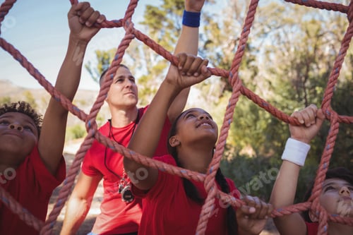 Preview: Trainer assisting kids in net climbing during obstacle course training