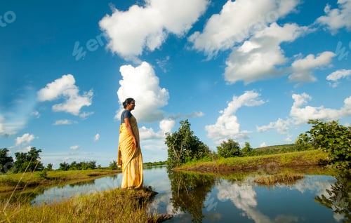 Preview: Indian woman alone in front of lake and enjoying the colors of nature.