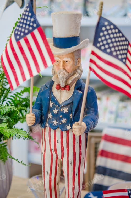 Preview: Uncle Sam figure holding a red white and blue American flag for Fourth of July celebration