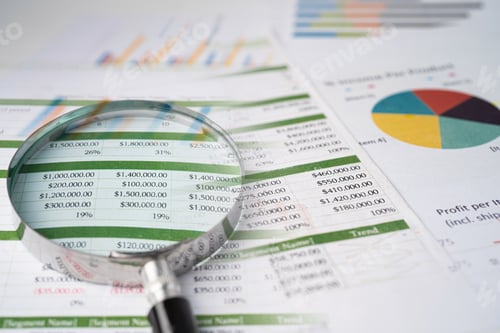 Preview: Magnifying glass on charts graphs paper.