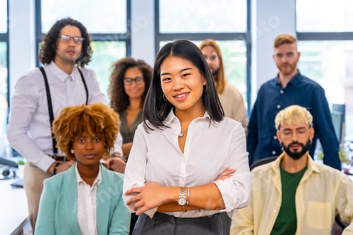 Preview: Proud chinese entrepreneur standing next to coworkers