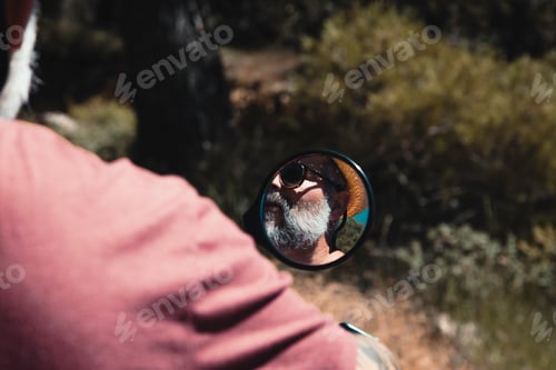 Preview: Reflection of Motorcycle Driver in Rearview Mirror