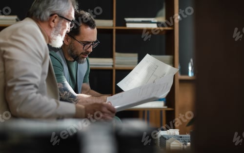 Preview: Young architect consulting project with senior colleague.