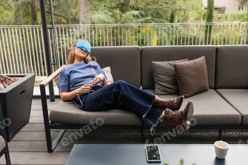 Preview: Woman relaxing on patio sofa wearing temperature controlled sleep mask