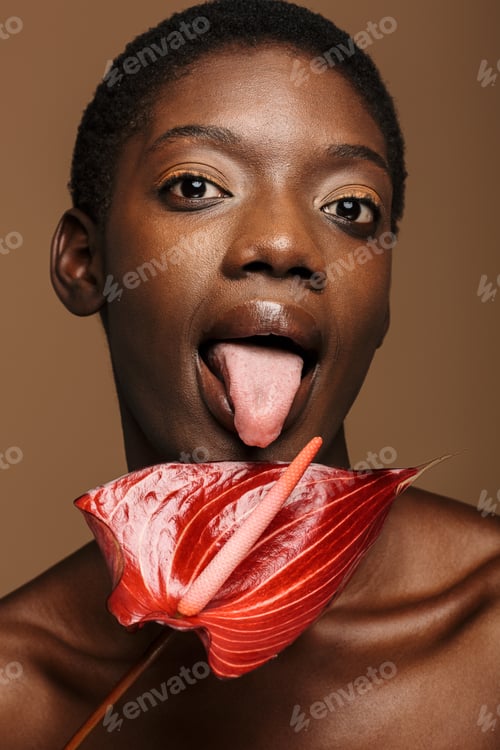 Preview: Beauty portrait of young half-naked african woman holding exotic flower